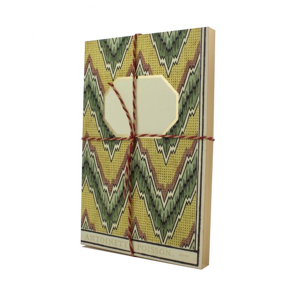 A notebook decorated with domino paper that showcases a horizontal yellow and green zig-zag pattern.