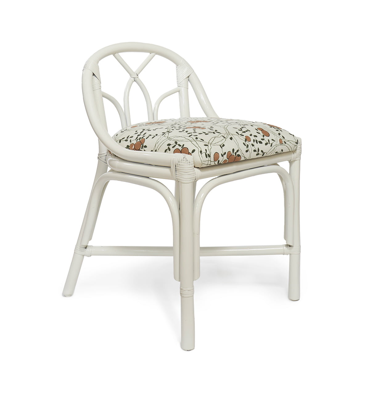 A white rattan chair with a white cushion with a pattern made up of small oranges on a vine.
